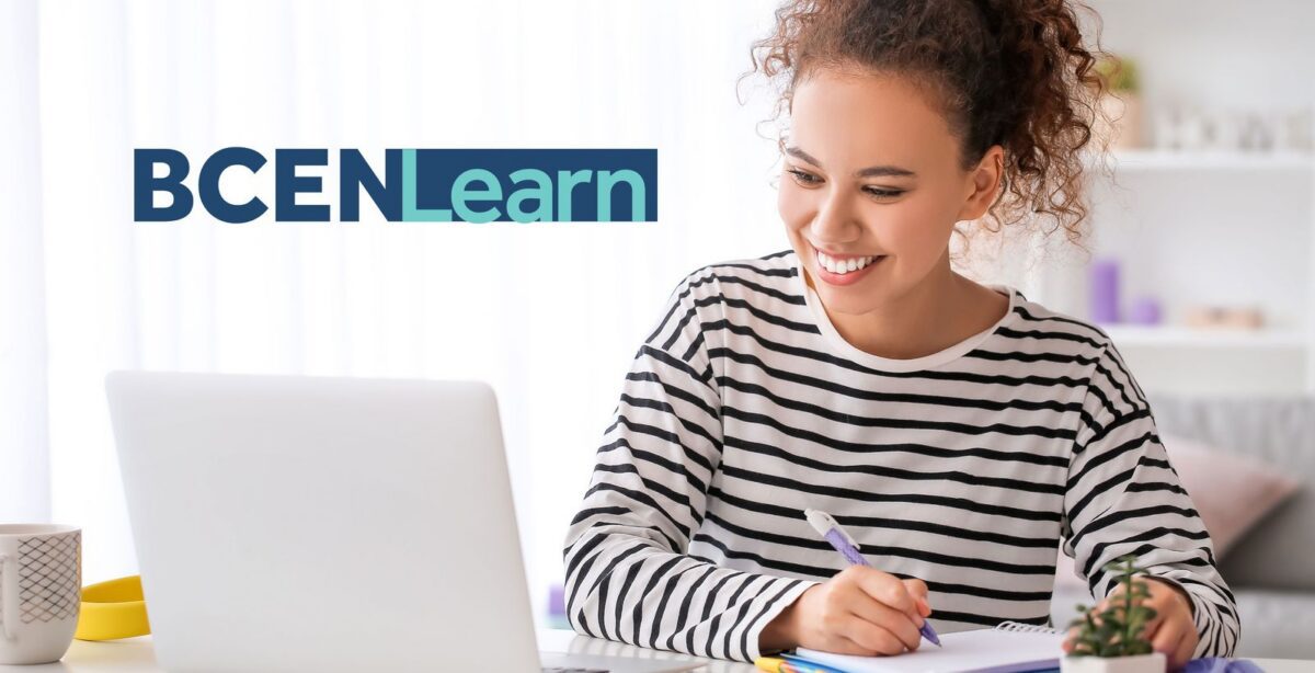 A woman in a striped shirt smiles while taking notes at a desk with a laptop, with the BCEN Learn logo displayed on the wall behind her.
