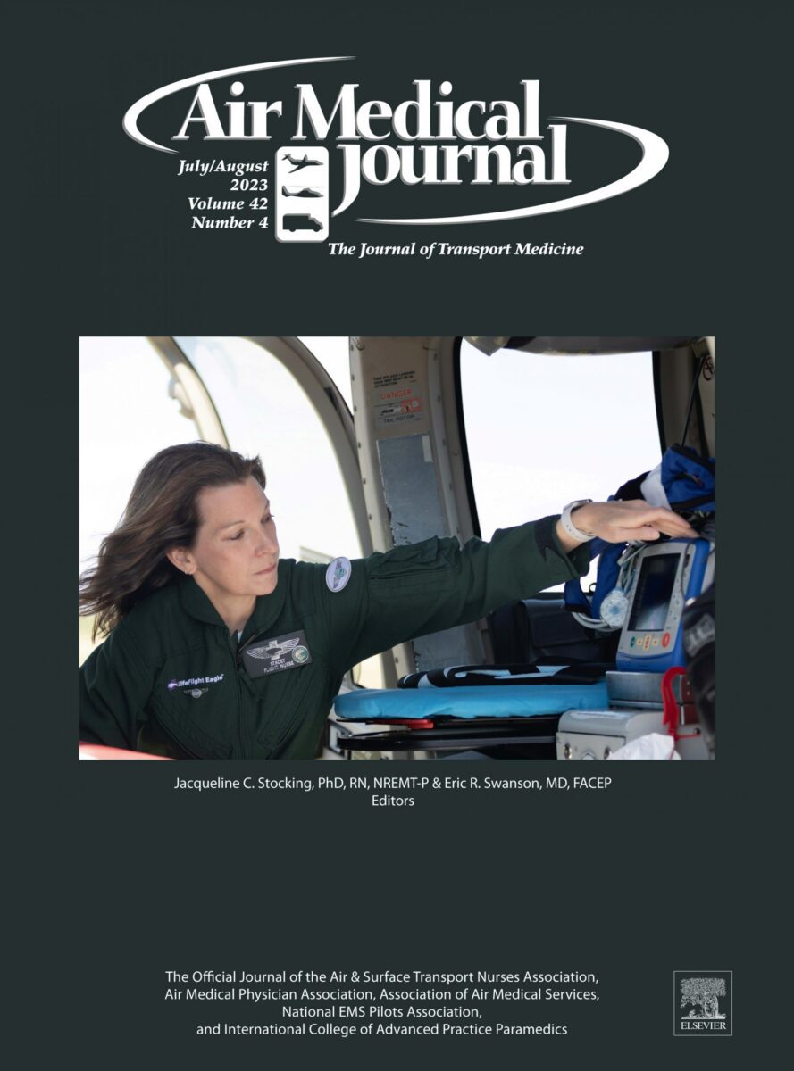 A flight nurse operates medical equipment inside an air ambulance cockpit, featured on the cover of Air Medical Journal July/August 2023 issue.