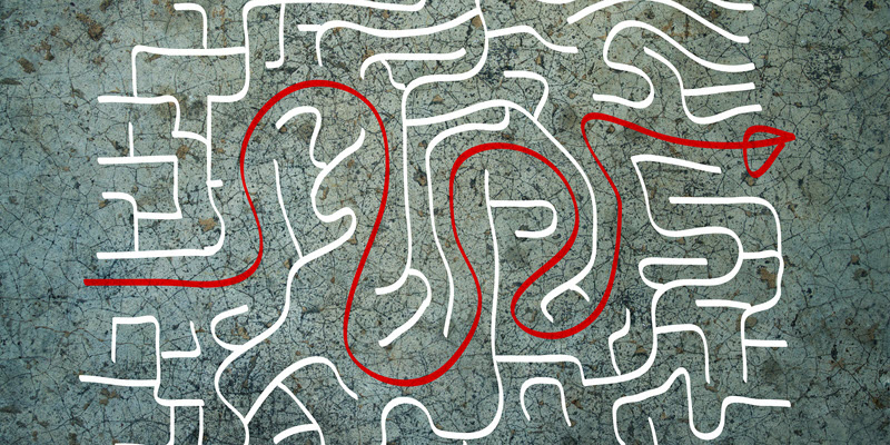 A winding red line traces a path through a white maze on a textured grey background, indicating a solution from start to finish.