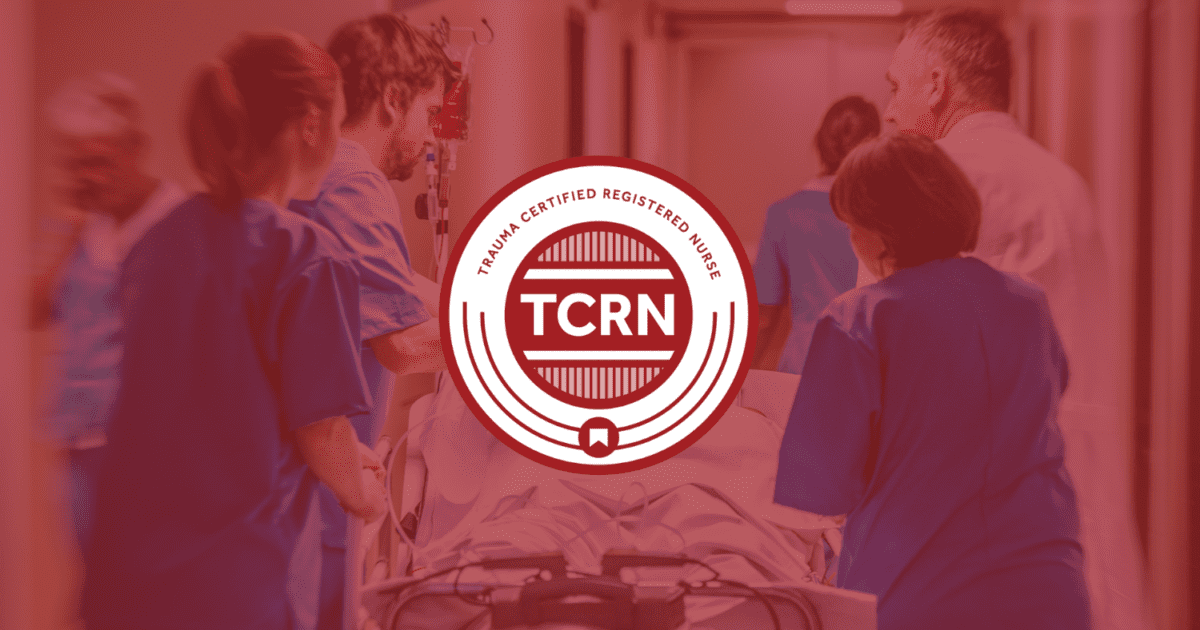 Medical team in scrubs pushes a patient on a stretcher down a hospital corridor; "Trauma Certified Registered Nurse (TCRN)" badge is superimposed on the image.