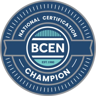 A circular badge featuring the text "National Certification Champion BCEN NCC award Est. 1980" in blue and white.