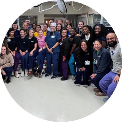 A large group of medical professionals posing together in a hospital room.