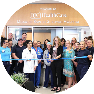 A group of medical staff and hospital employees holding a blue ribbon at a ribbon-cutting ceremony for Missouri Baptist Sullivan Hospital.